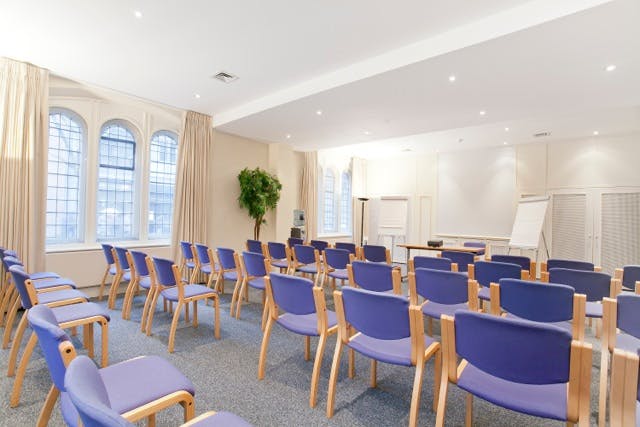 Trevelyan Hall meeting room with blue chairs, ideal for workshops and presentations.