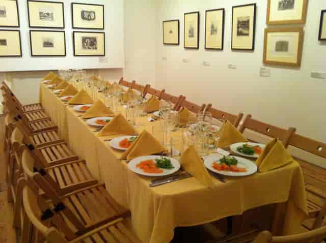 Elegant dining table setup with yellow tablecloth for corporate dinner in Estorick Collection.