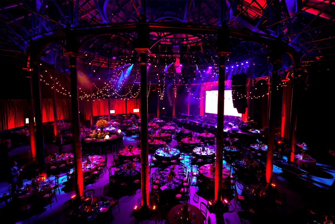 Vibrant event space in Roundhouse with elegant tables, ideal for corporate gatherings.