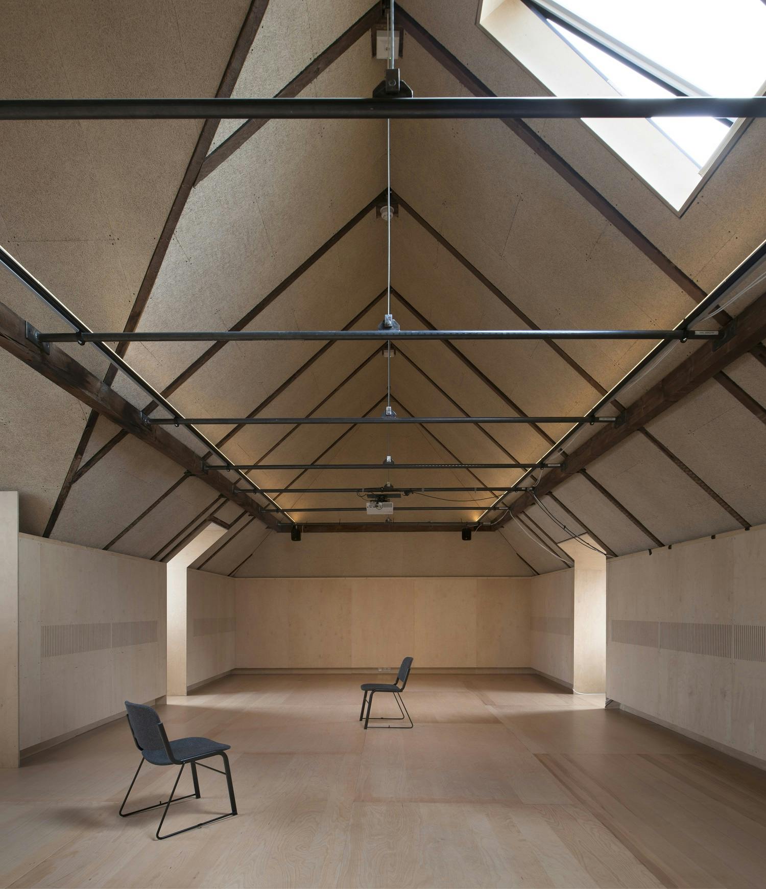 Spacious meeting room with sloped ceiling, ideal for workshops and corporate retreats.