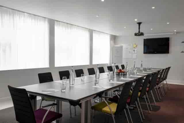 Modern meeting room at K West Hotel with sleek table, ideal for workshops and presentations.