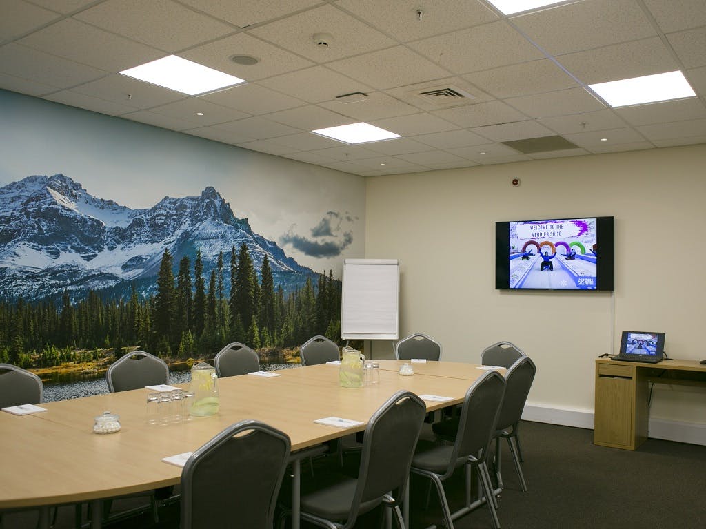 Vail Suite meeting room with wooden table, mountains backdrop, ideal for conferences and brainstorming.