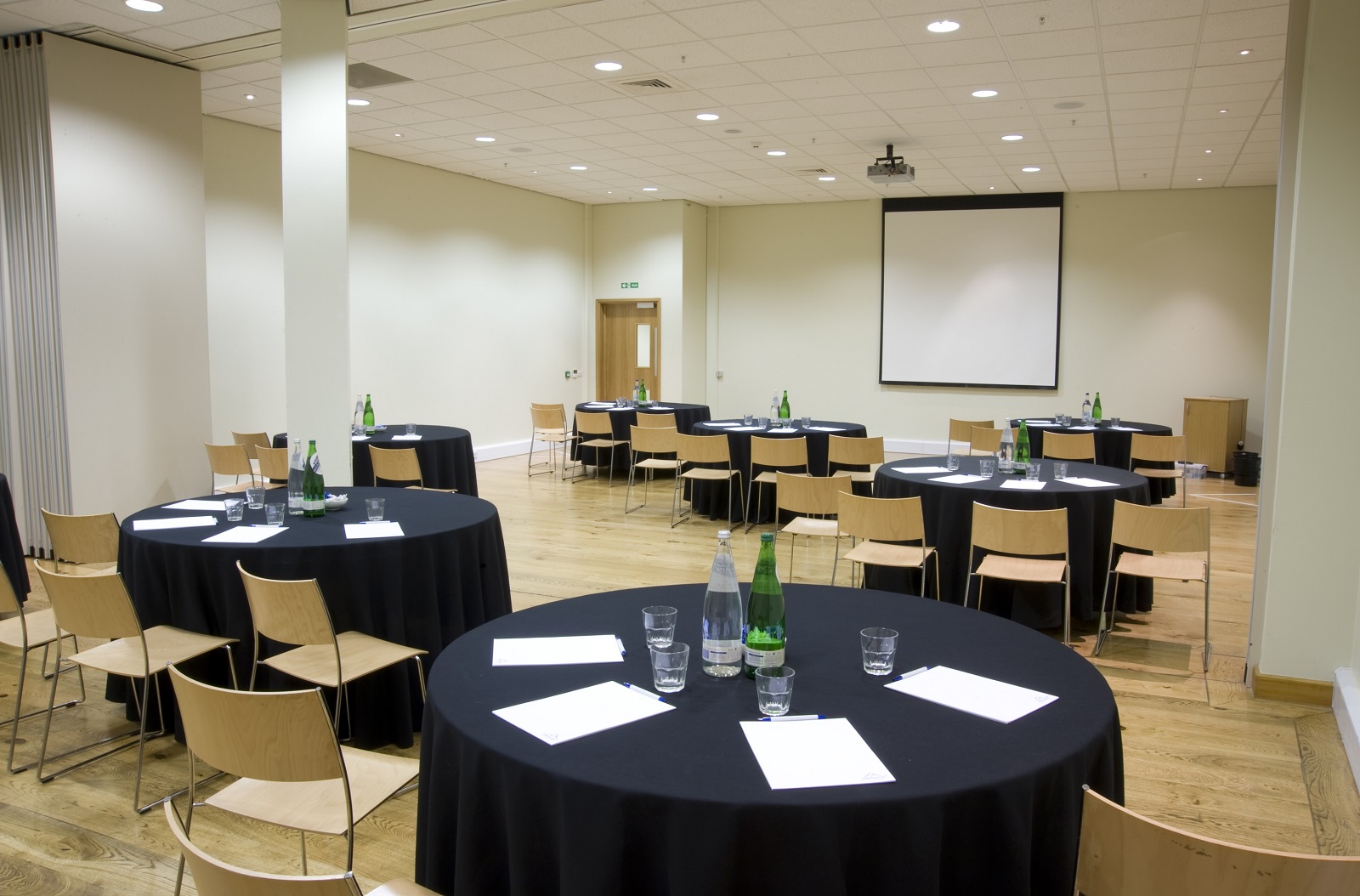 Anton & Aspen Suite at Chill Factore, set for a workshop with round tables and projector. - Banner