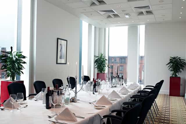 Boardroom at Hilton Deansgate, elegant dining setup for corporate events and gatherings.
