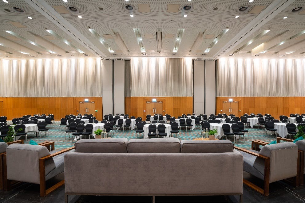 Deansgate Suite at Hilton: elegant conference venue with round tables and soft lighting.