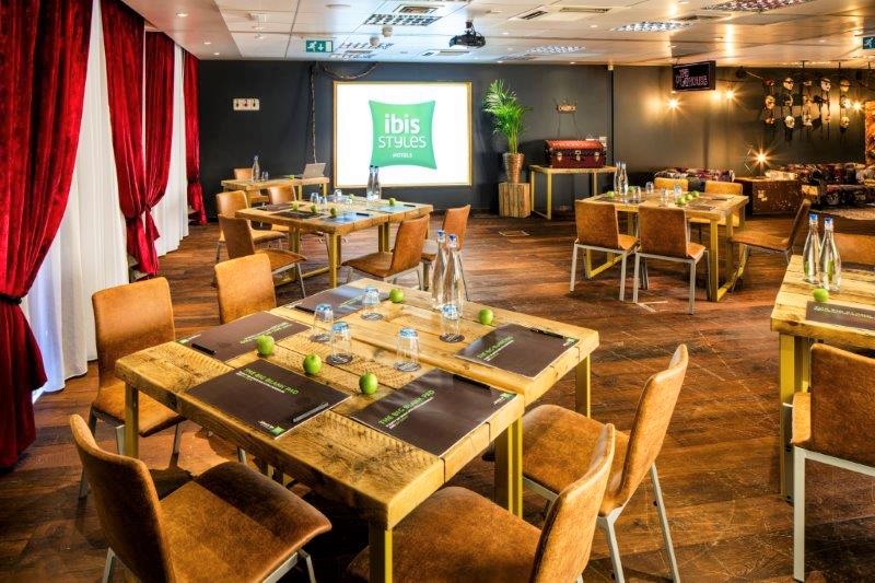 Versatile meeting space with wooden tables for workshops and team-building events. - Banner