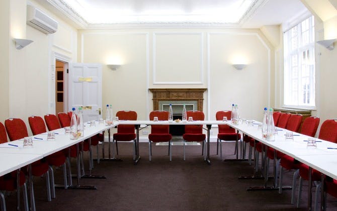 Warren Suite meeting room with U-shaped table, bright decor for conferences and events.