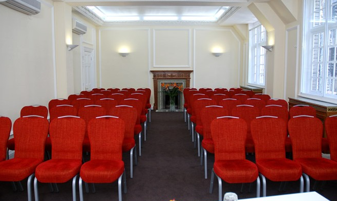 Warren Suite meeting room with red chairs, ideal for presentations and workshops. - Banner
