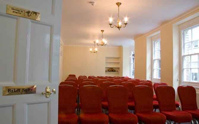 Baker Suite meeting room with red chairs, ideal for corporate events and presentations.