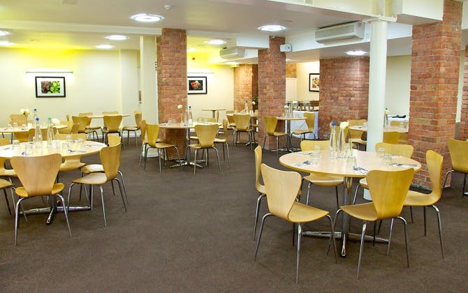 Hallam Café event space with round tables, ideal for meetings and workshops.