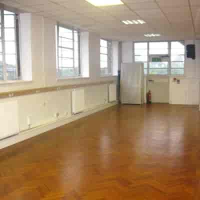 Dance school meeting room with wooden flooring, ideal for workshops and gatherings.