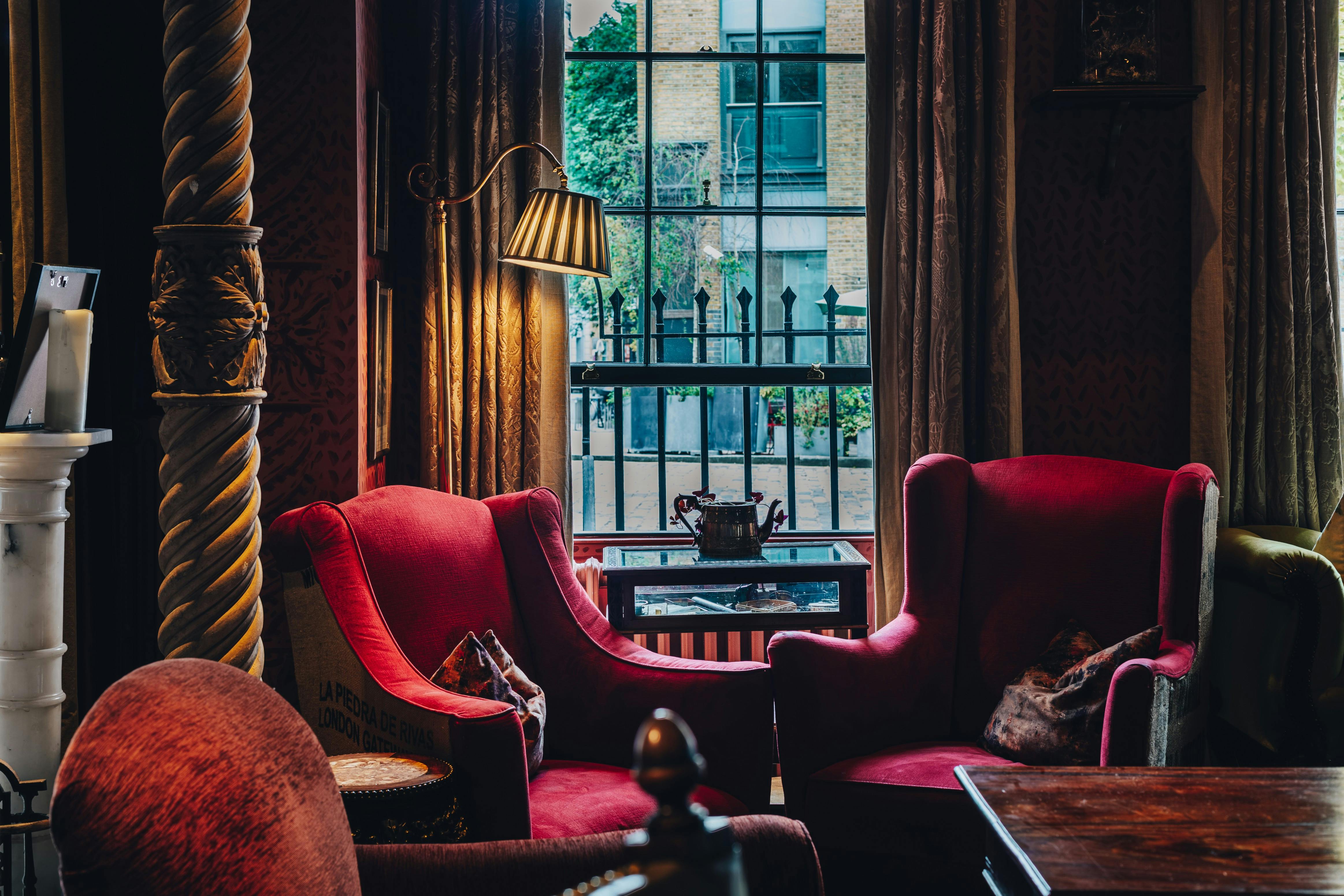 Cozy meeting space with plush red armchairs for creative workshops and discussions.