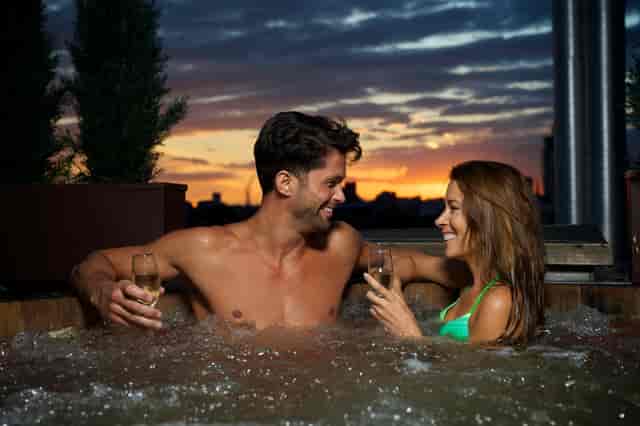 Couple in hot tub at sunset in Lucy Loft Suite, perfect for romantic retreats and events.