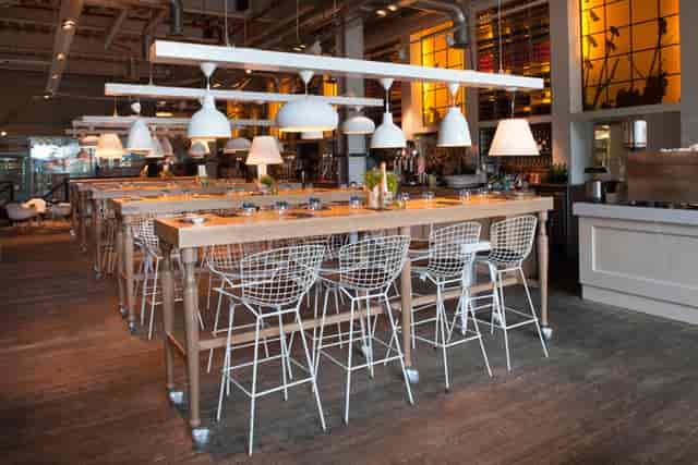 Modern dining venue with communal tables for events and gatherings in The Parlour.