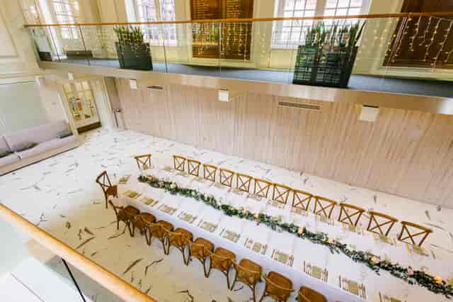 Elegant Garden Room banquet, cross-back chairs, floral runner, upscale event.