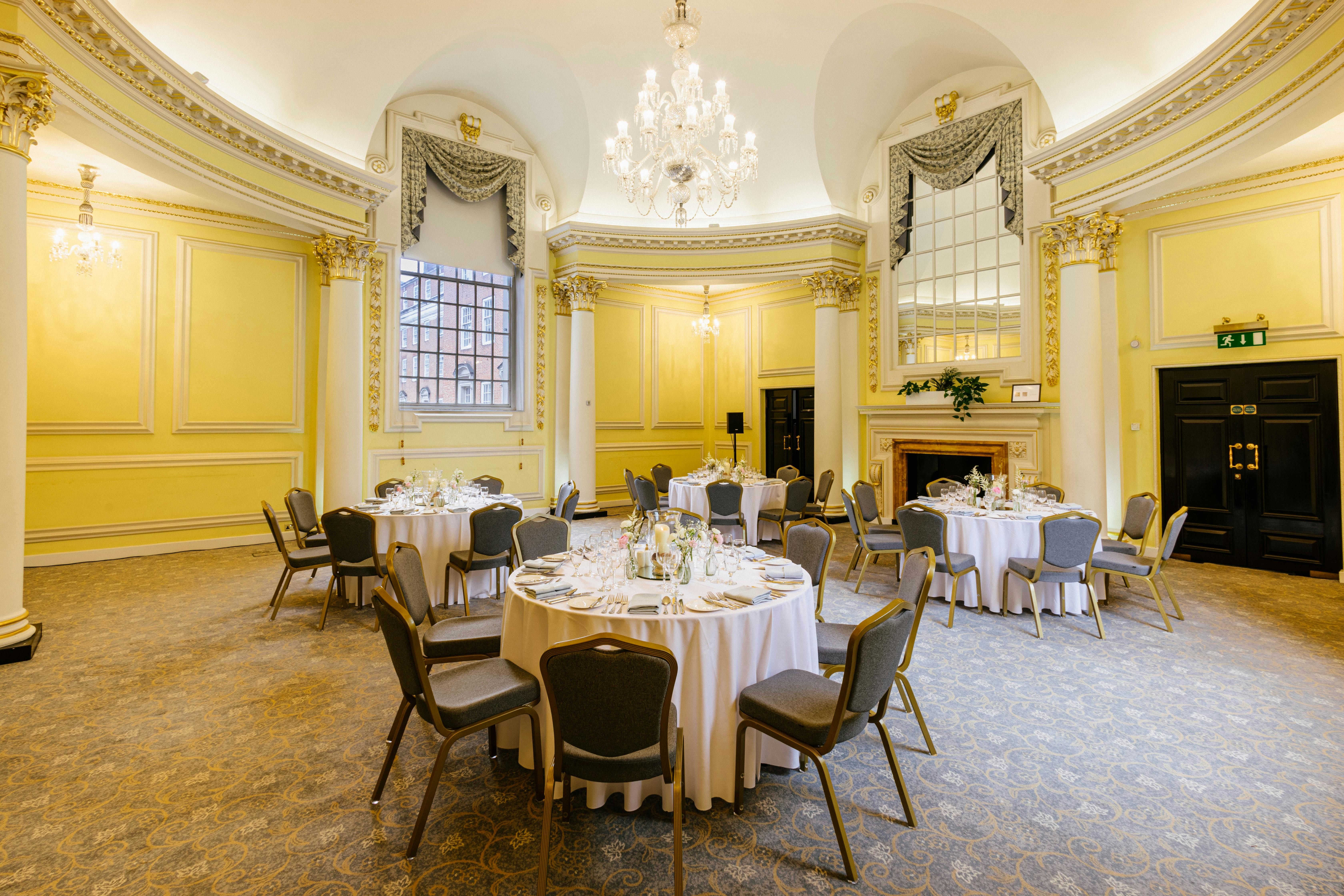Elegant event space with yellow walls, ideal for corporate meetings and intimate gatherings.