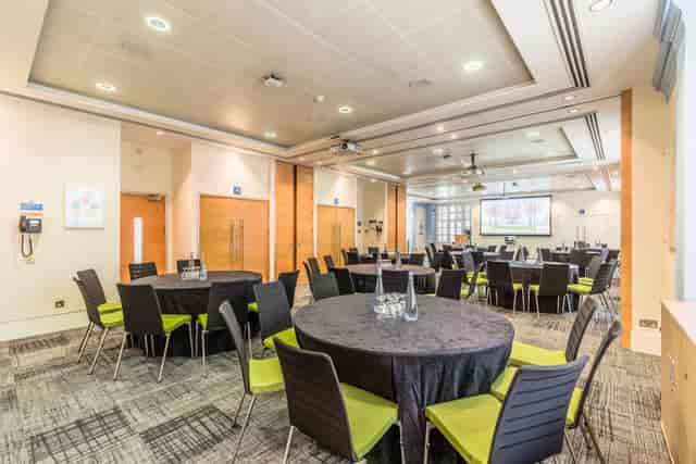 Courtyard Suite at BMA House, modern meeting space with round tables for events.