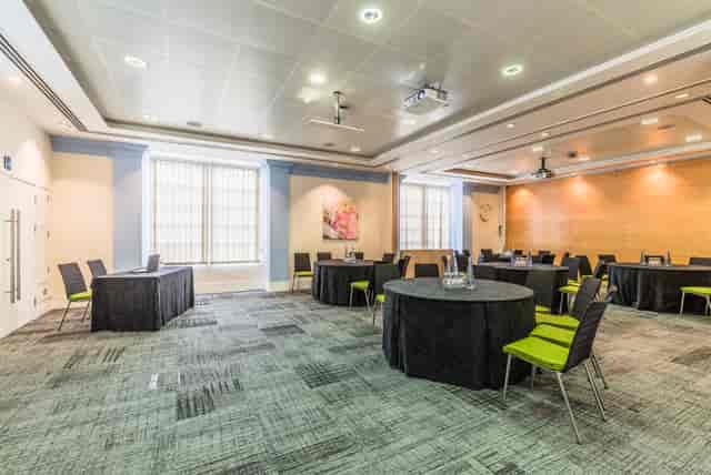 Murrell Barnes Suite: modern meeting space with round tables, ideal for workshops and presentations.