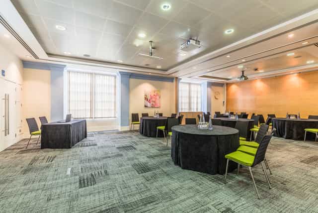 Murrell Barnes Suite: modern meeting space with round tables, ideal for workshops and presentations.