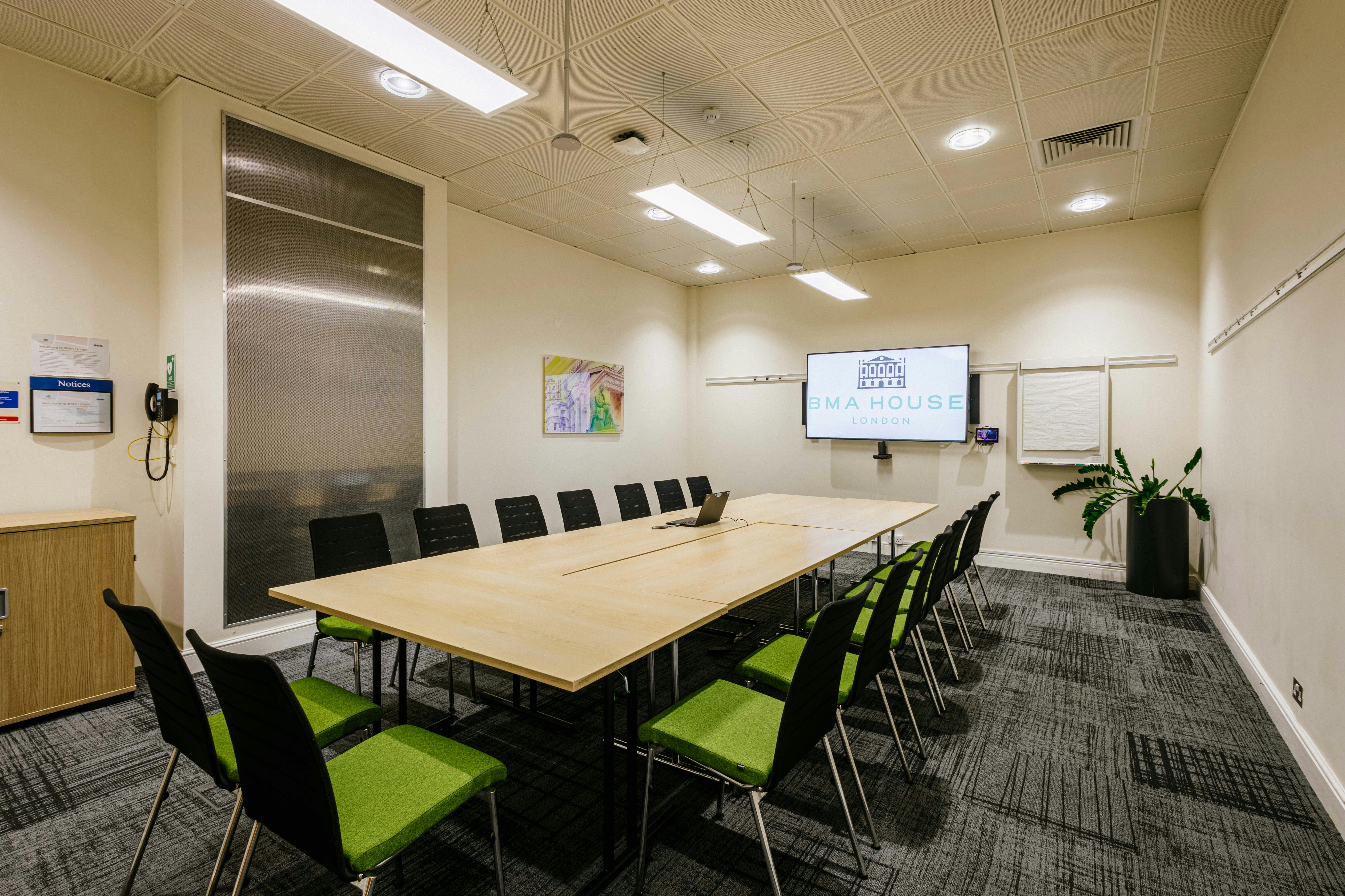 Modern meeting room in BMA House with green chairs, ideal for brainstorming sessions.