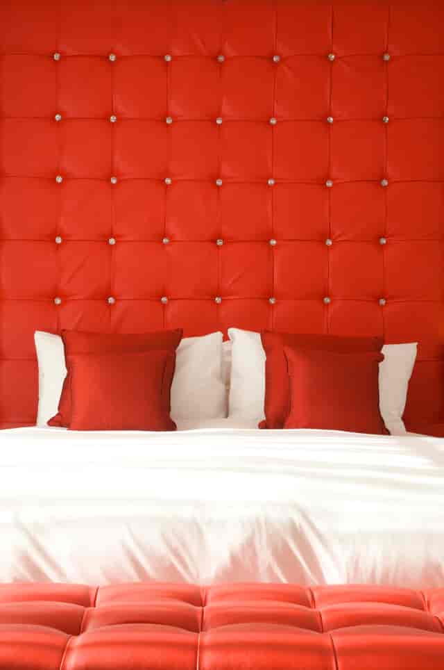 Ruby Loft Suite with red headboard, ideal for creative retreats and events.