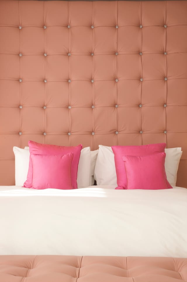 Jude Loft Suite at Bermondsey Square Hotel, plush pink headboard, upscale event space.