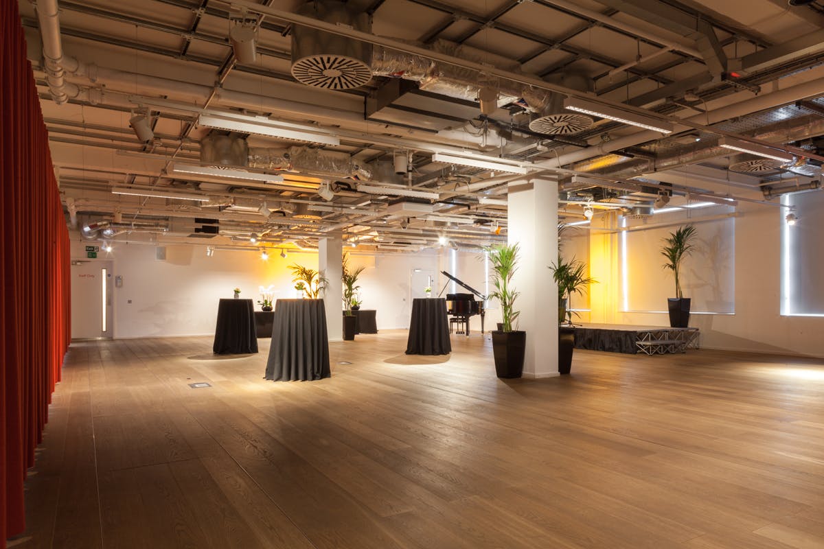 Versatile auditorium venue with polished wooden floor for corporate events and receptions.