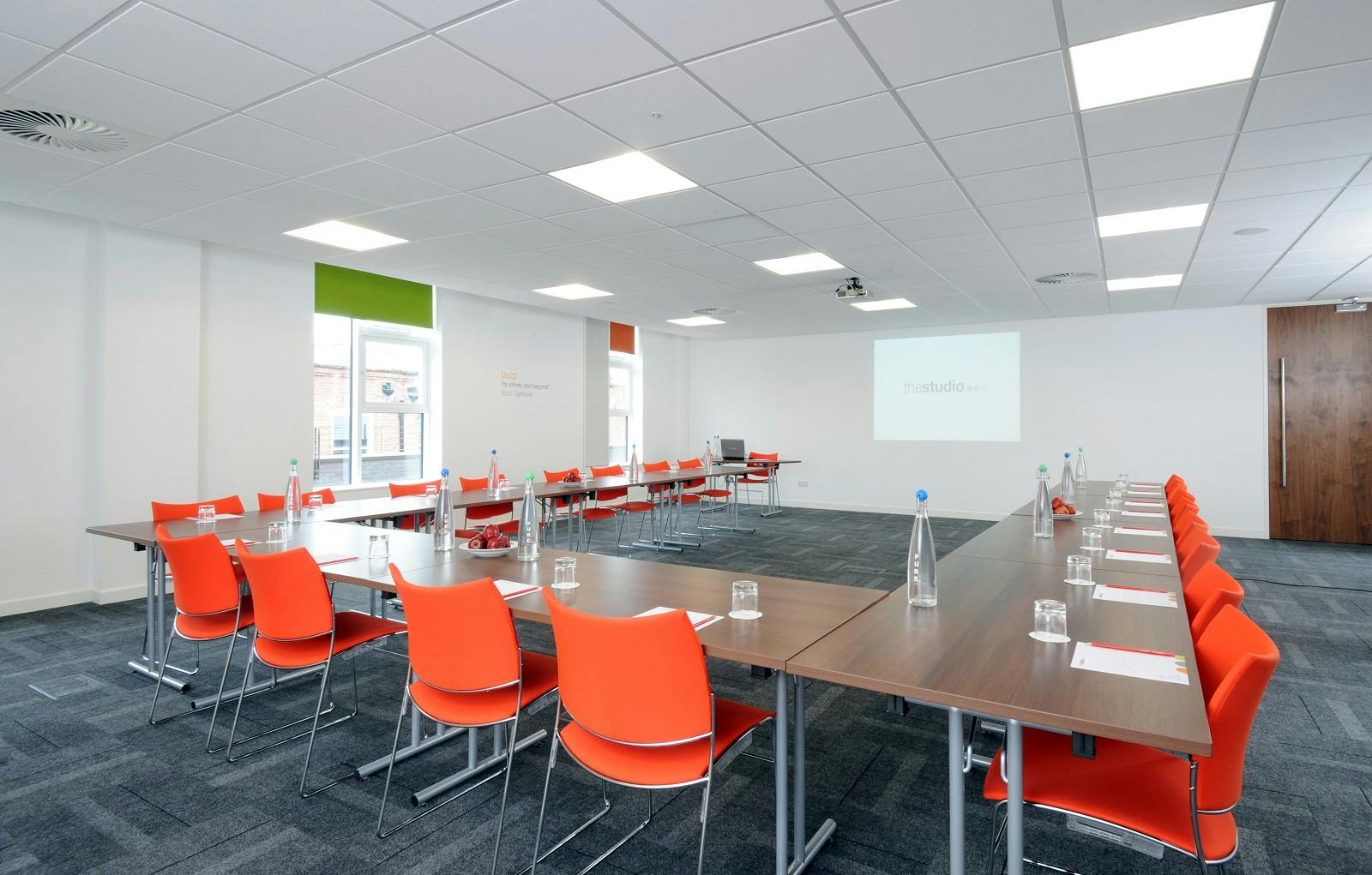 Modern meeting room in Manchester with orange chairs for professional gatherings.