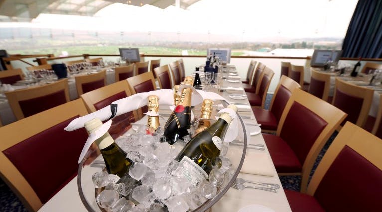 Elegant dining table with champagne at Cheltenham Racecourse for corporate events.