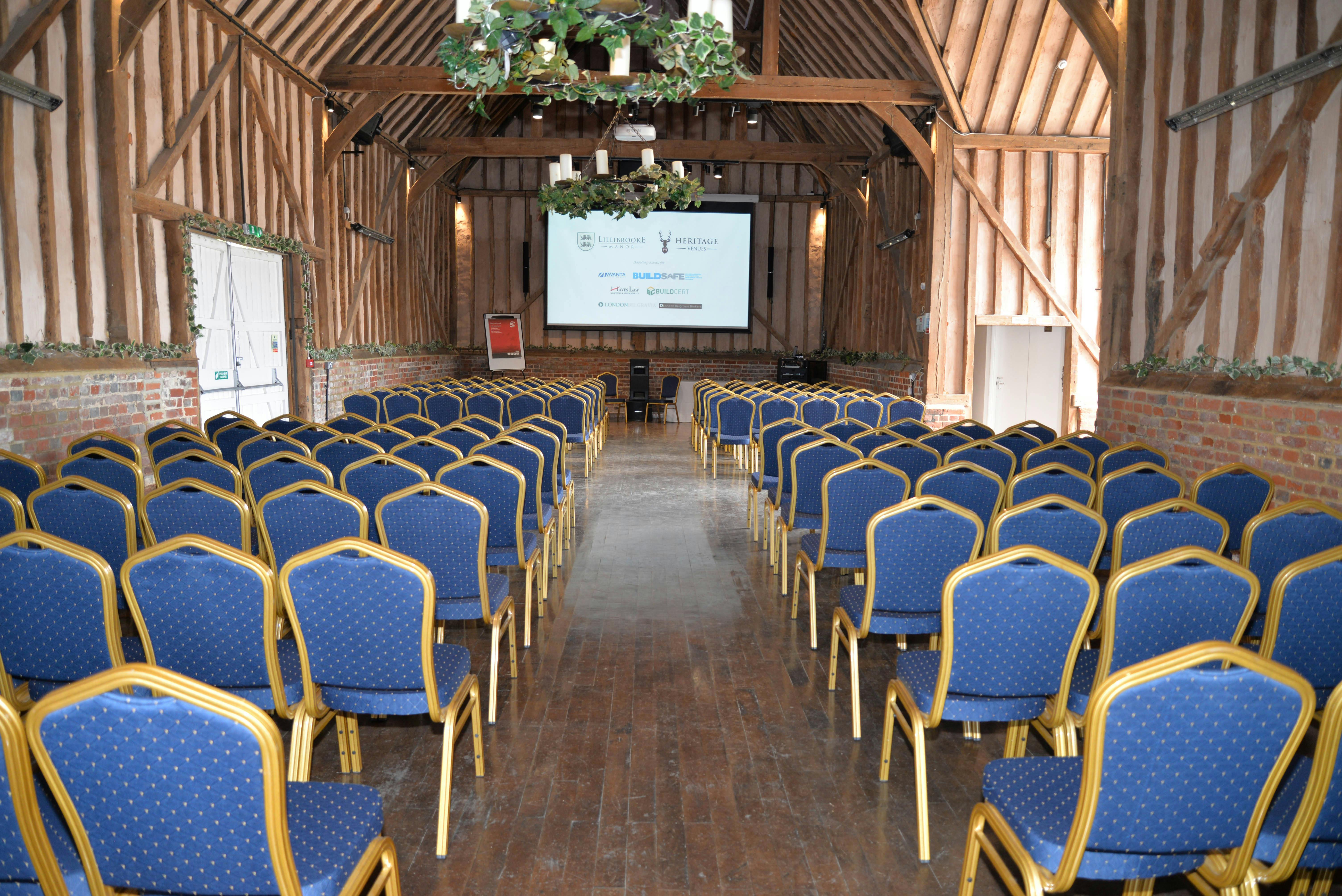 Great Barn event space with blue chairs, ideal for conferences and workshops.