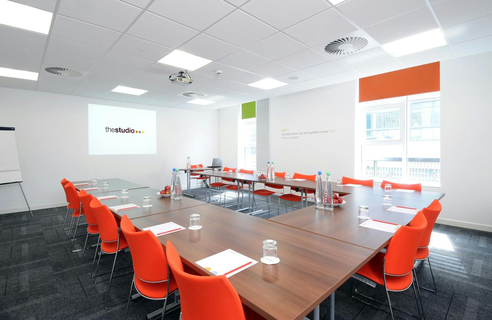 Modern meeting room in Manchester with U-shaped tables, ideal for workshops and planning.