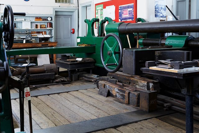 Vintage workshop with large machinery, ideal for team-building events and workshops.