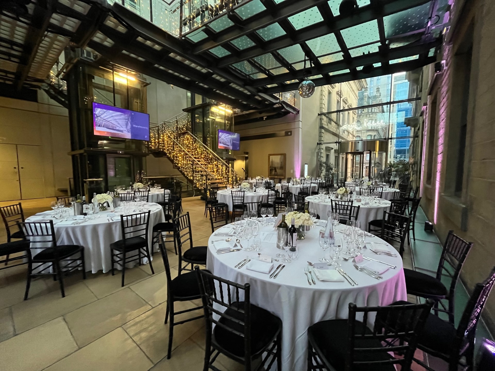 Atrium at Manchester Art Gallery: elegant event space with round tables for corporate gatherings. - Banner
