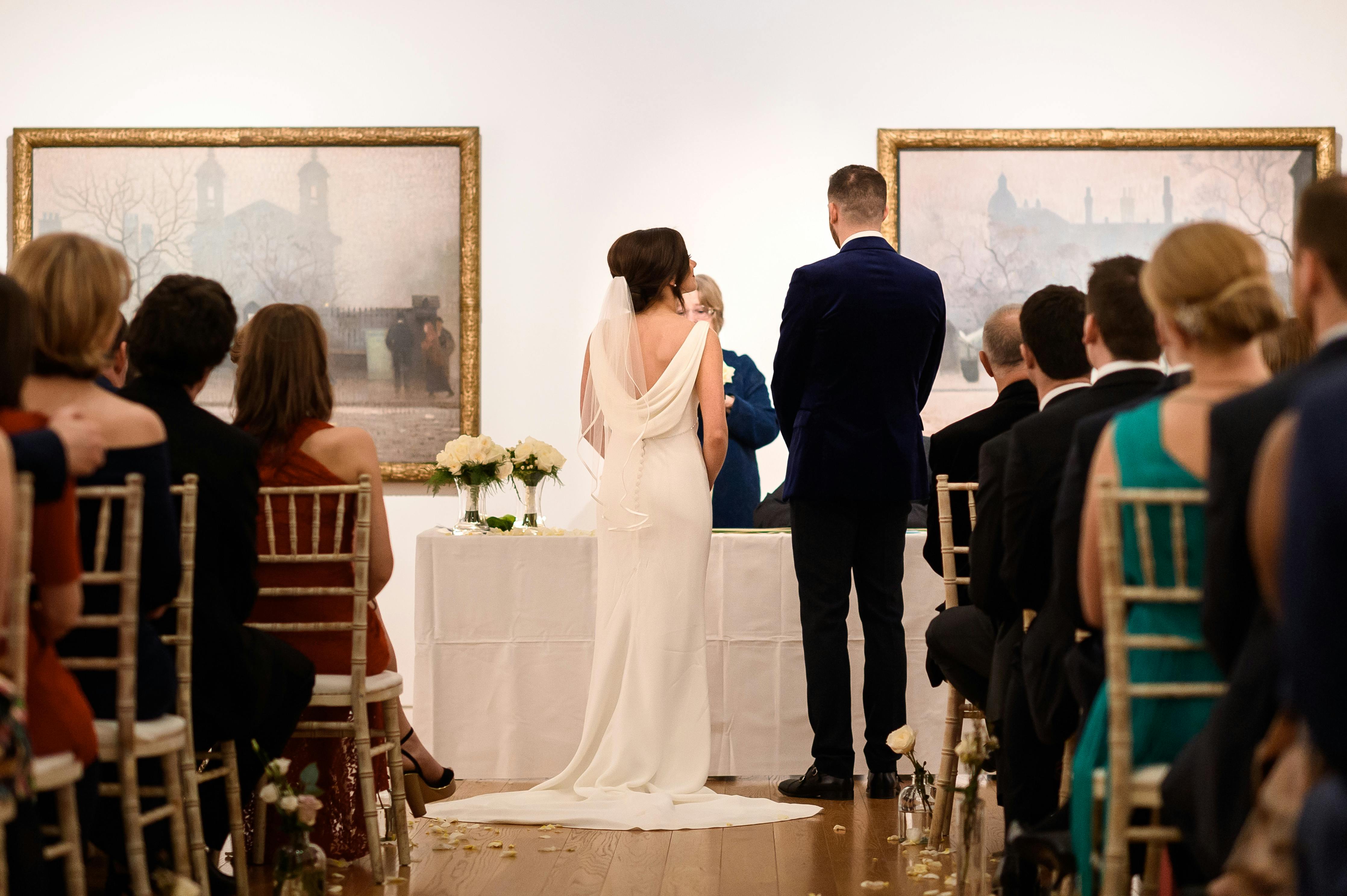 Elegant wedding ceremony at Manchester Art Gallery with floral decor and intimate atmosphere.