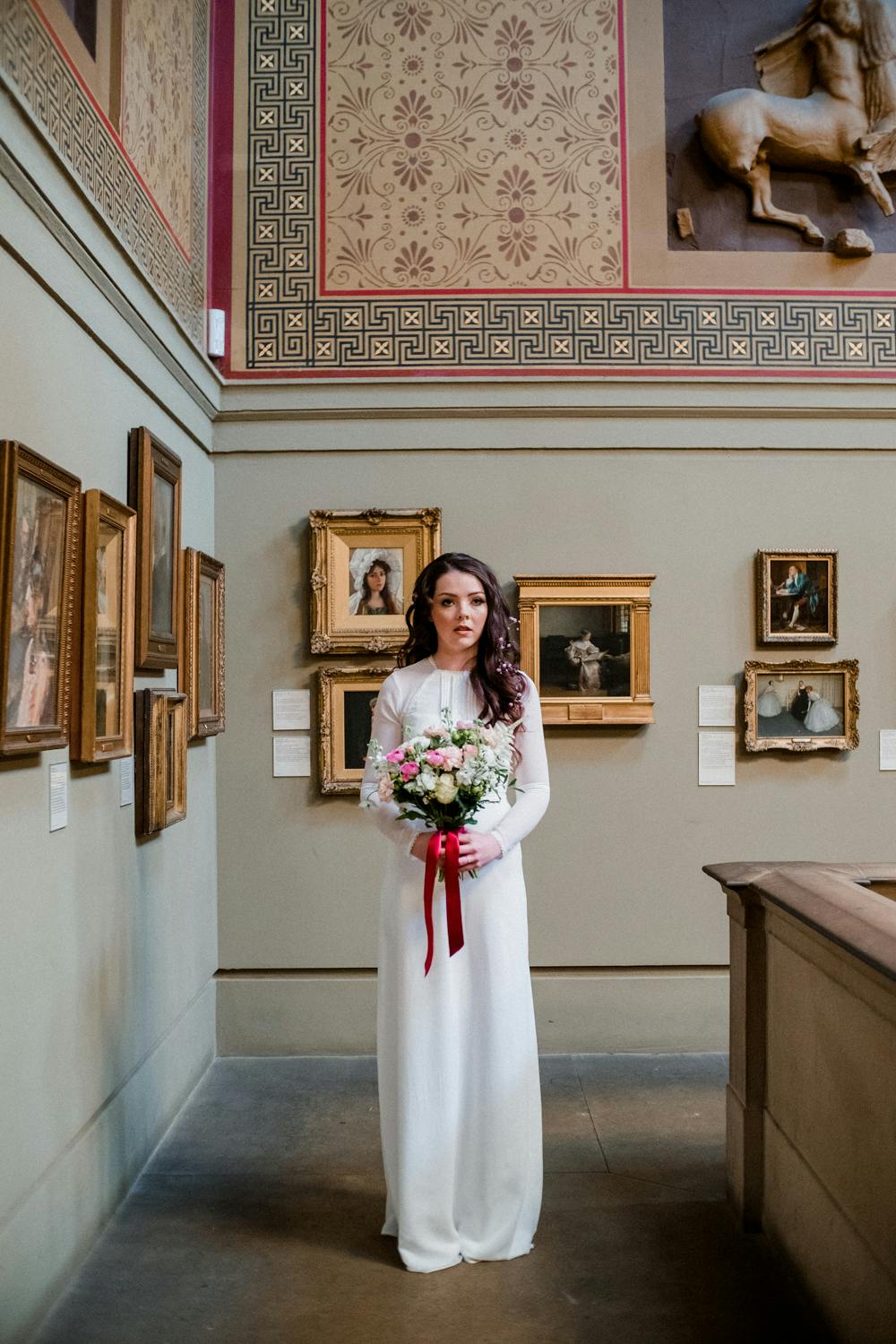 Bride in Victorian Hall, Manchester Art Gallery; elegant wedding venue with art.