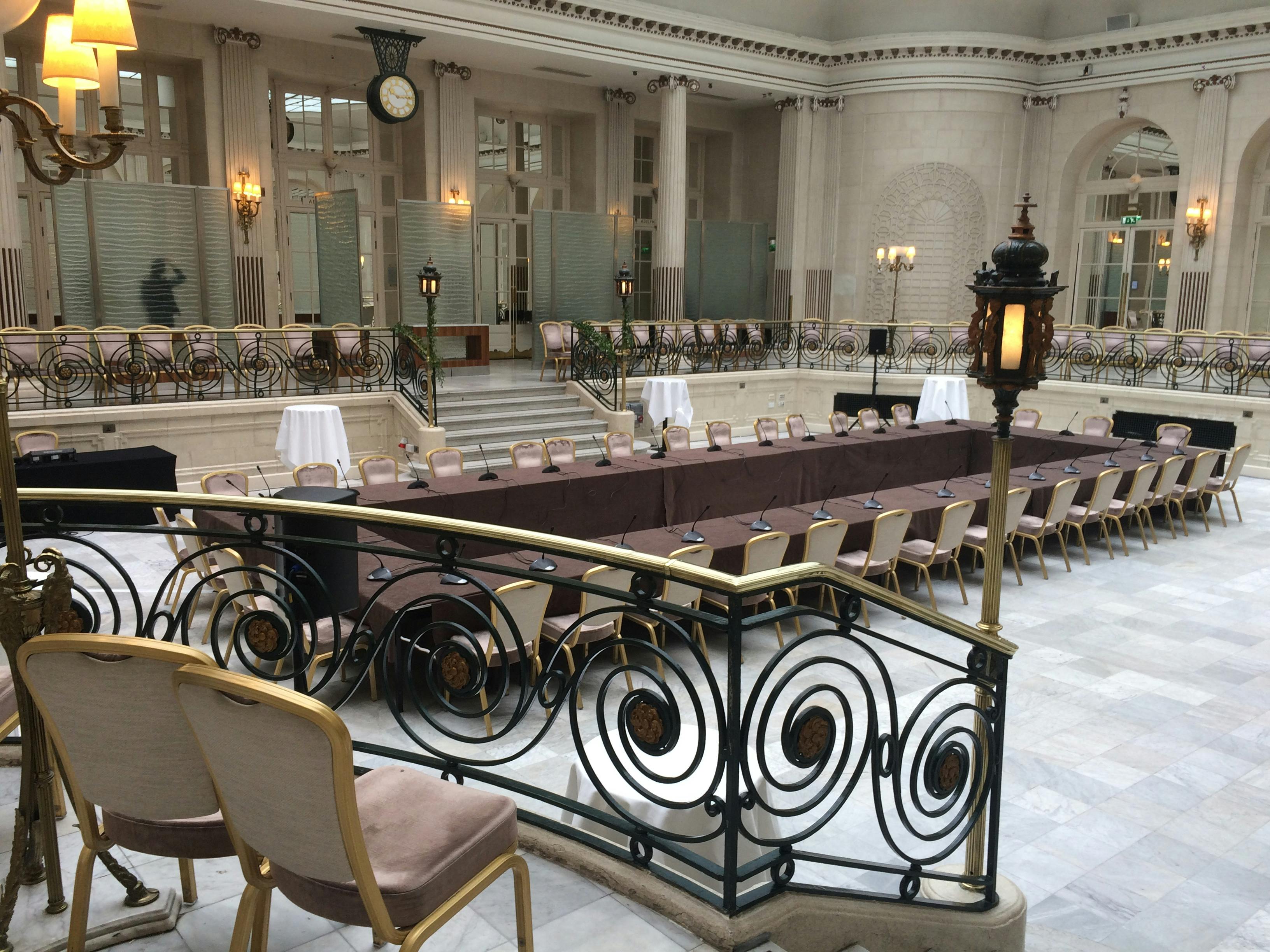 Elegant Palm Court at The Waldorf Hilton, London, set for a formal corporate meeting.