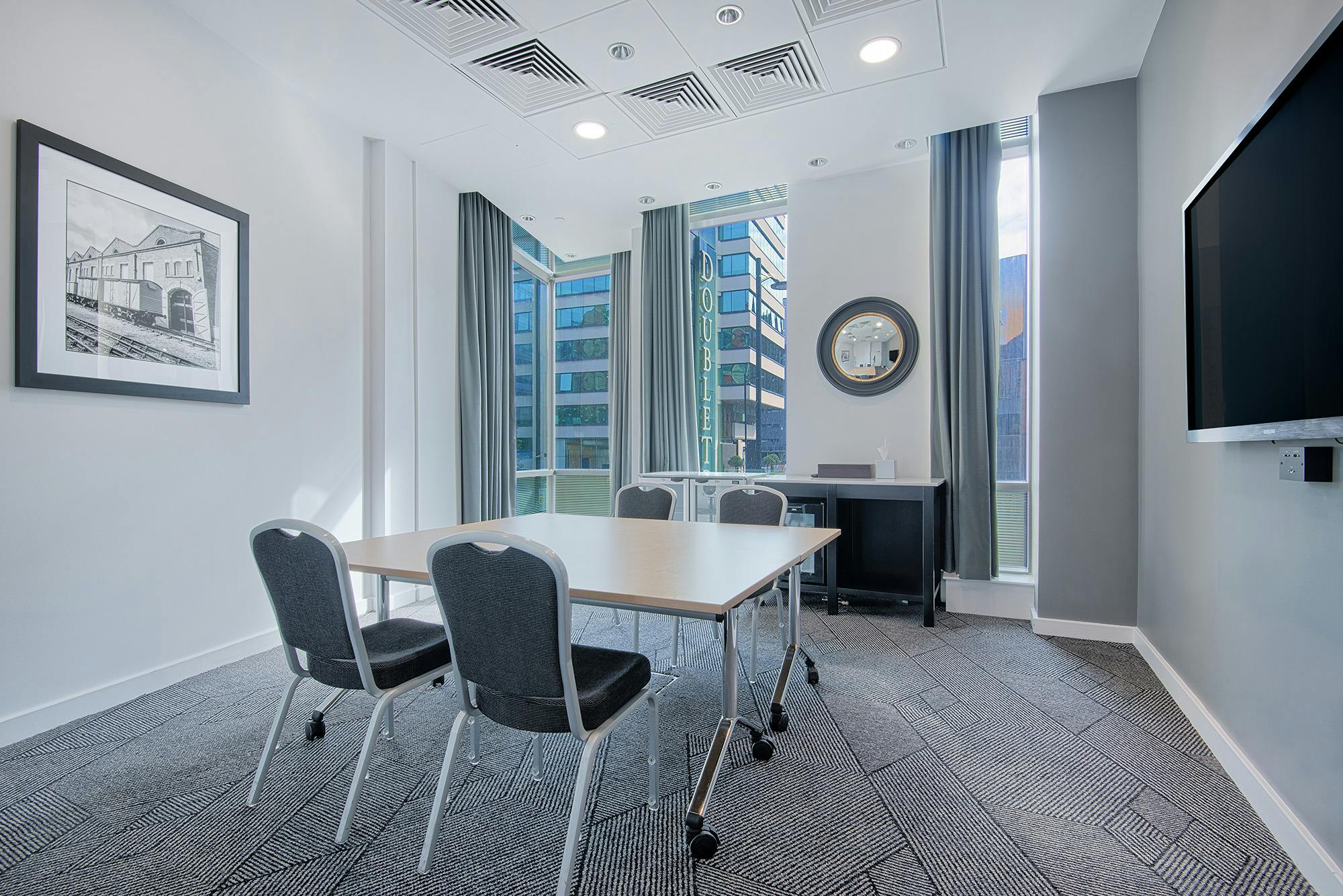 Modern meeting room at DoubleTree Manchester with natural light, perfect for workshops.