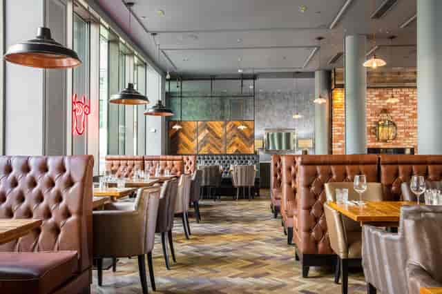 Modern restaurant at DoubleTree Manchester with plush seating, ideal for events.