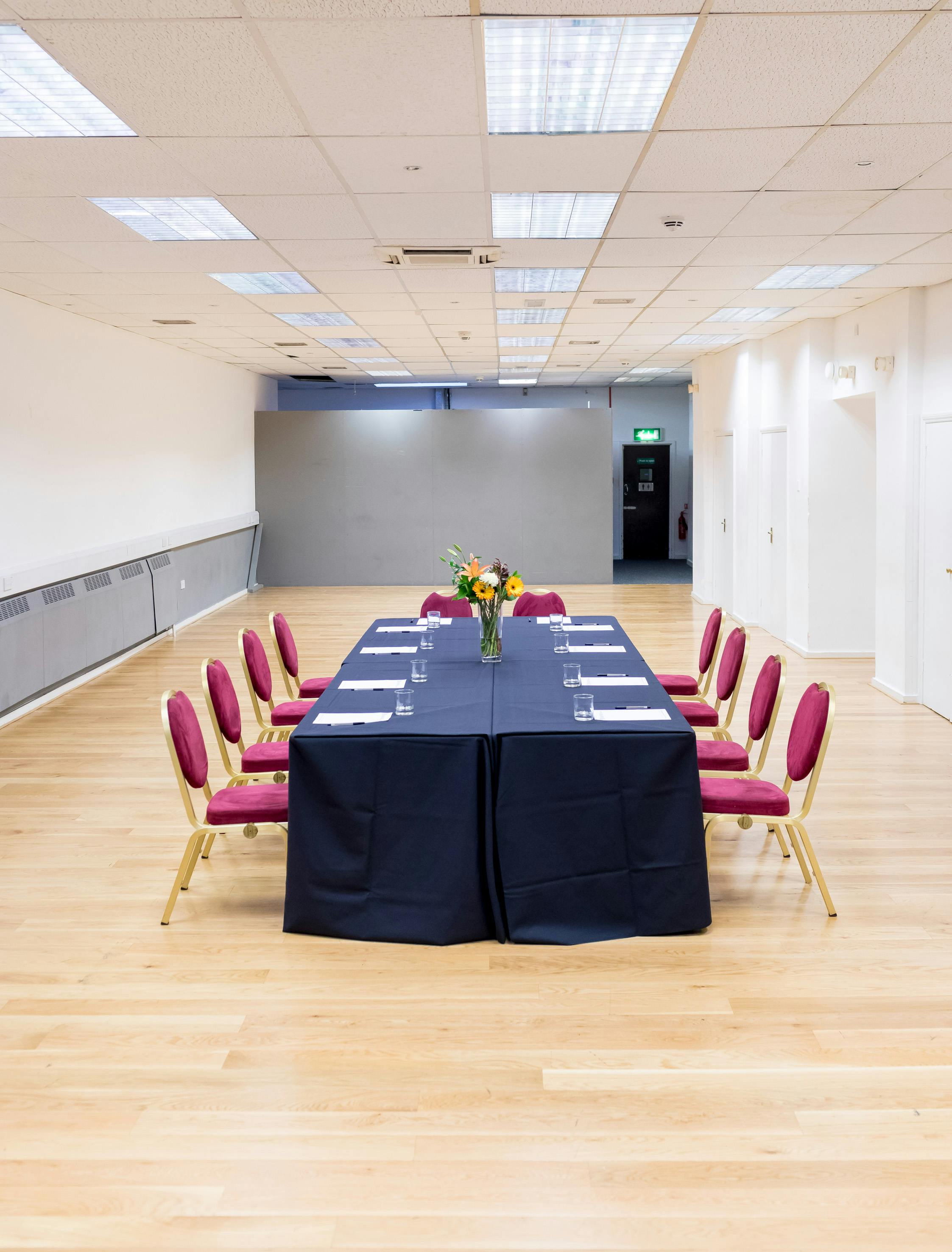 Formal meeting space at Dominion Theatre with navy tablecloth and floral centerpiece.