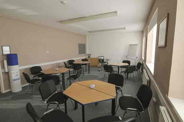 Versatile meeting space in Ayton House with hexagonal tables for workshops and gatherings.