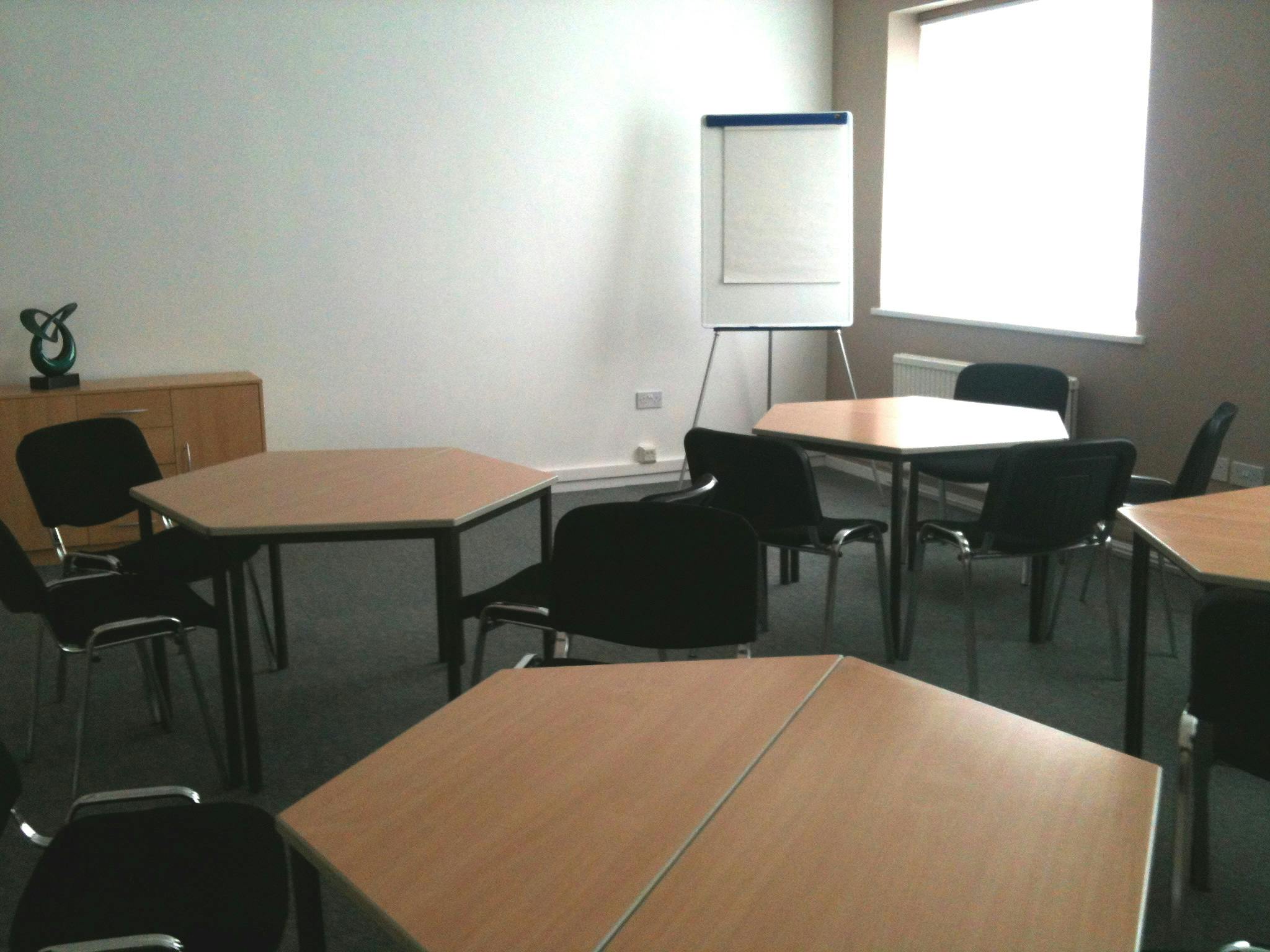 Versatile meeting space in Ayton House with hexagonal tables for workshops and brainstorming.