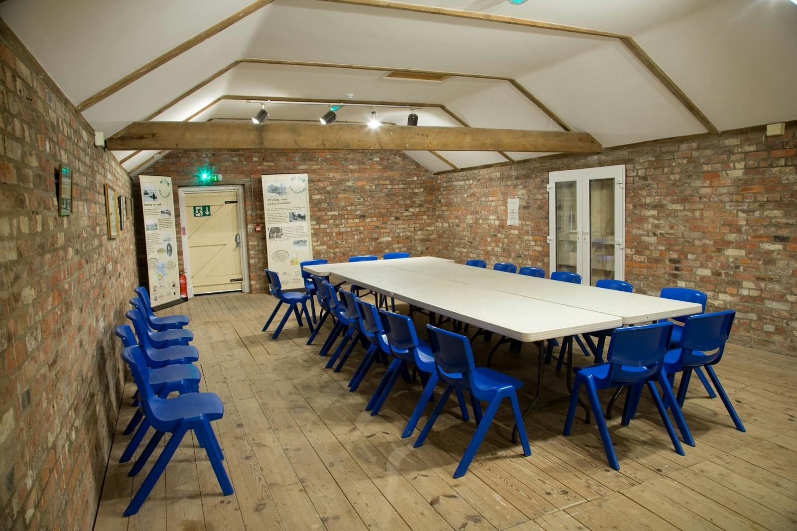 Haven House Exhibition Hall with long table, ideal for workshops and meetings.