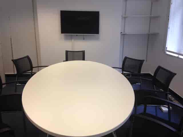 Functional coworking breakout room with oval table for collaborative meetings and team workshops.