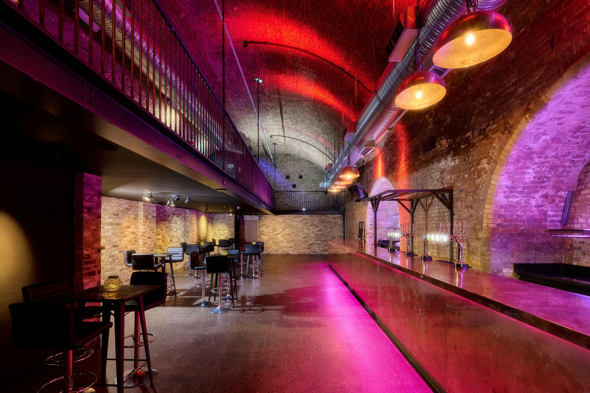 Stylish event space at The Steel Yard with modern bar and exposed brick walls.