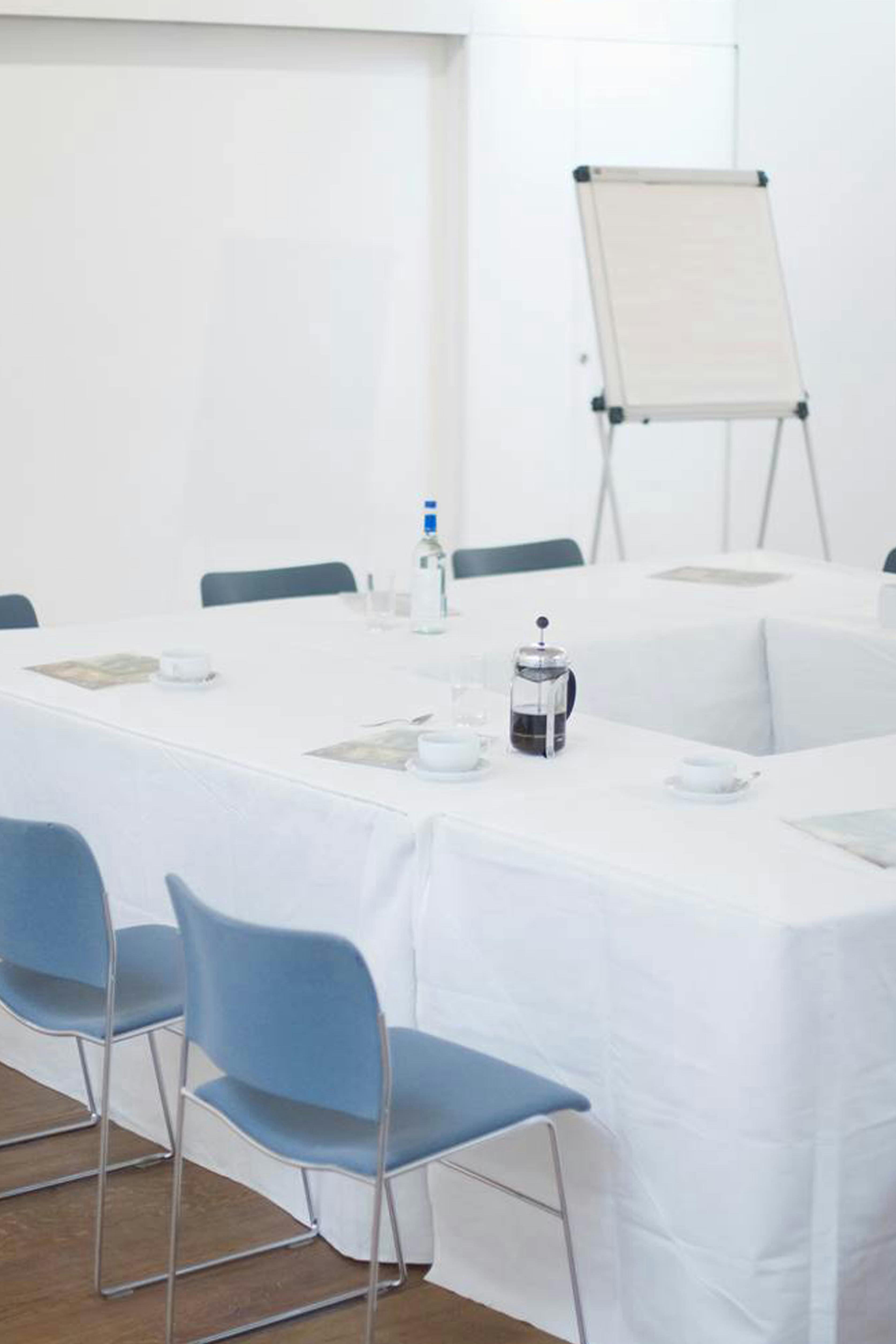 Linbury Room meeting space with white table setup for professional discussions and presentations.