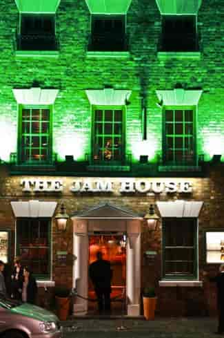 Vibrant Jam House venue with green lighting, ideal for live music and corporate events.