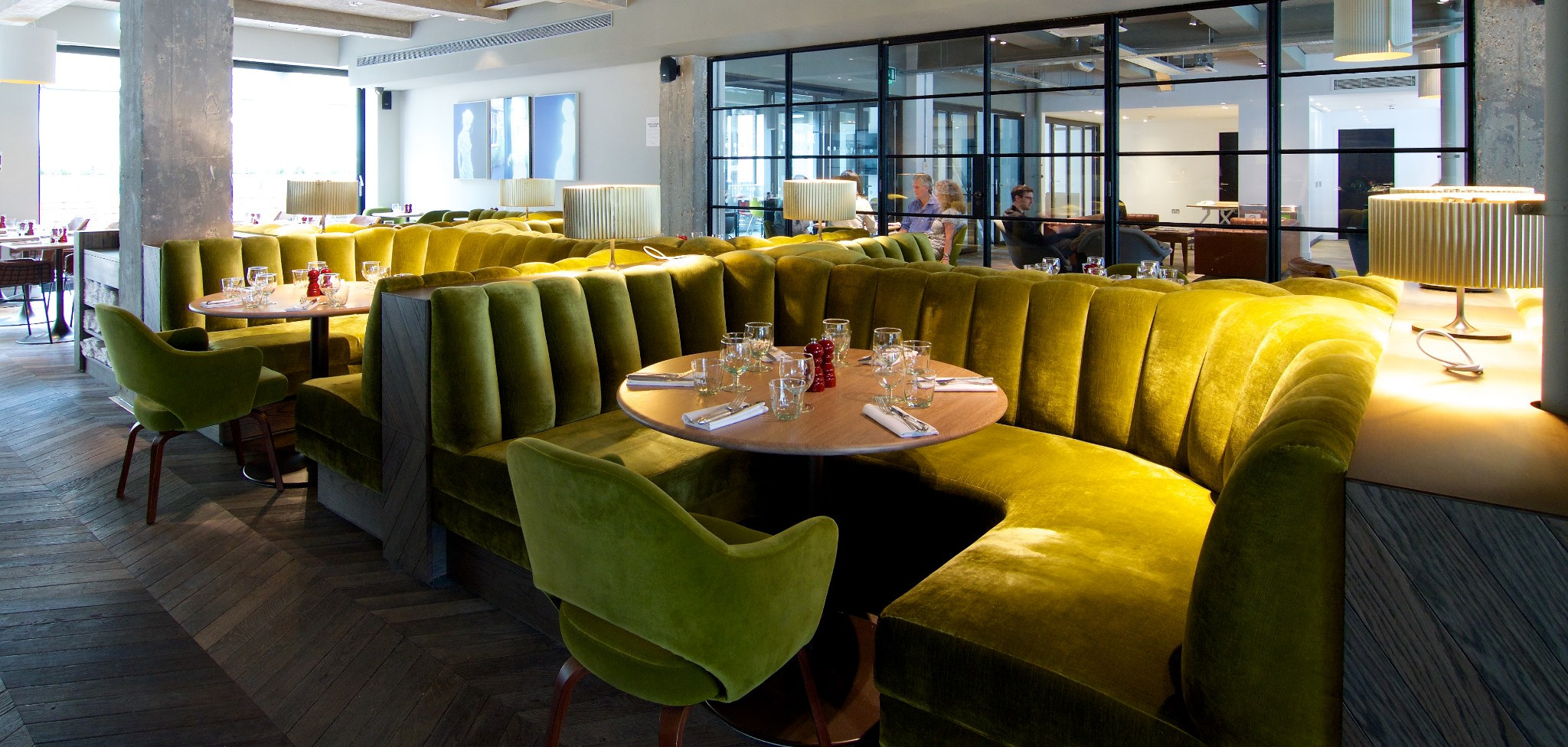 Stylish dining area with velvet seating for exclusive hire events in vibrant green tones. - Banner