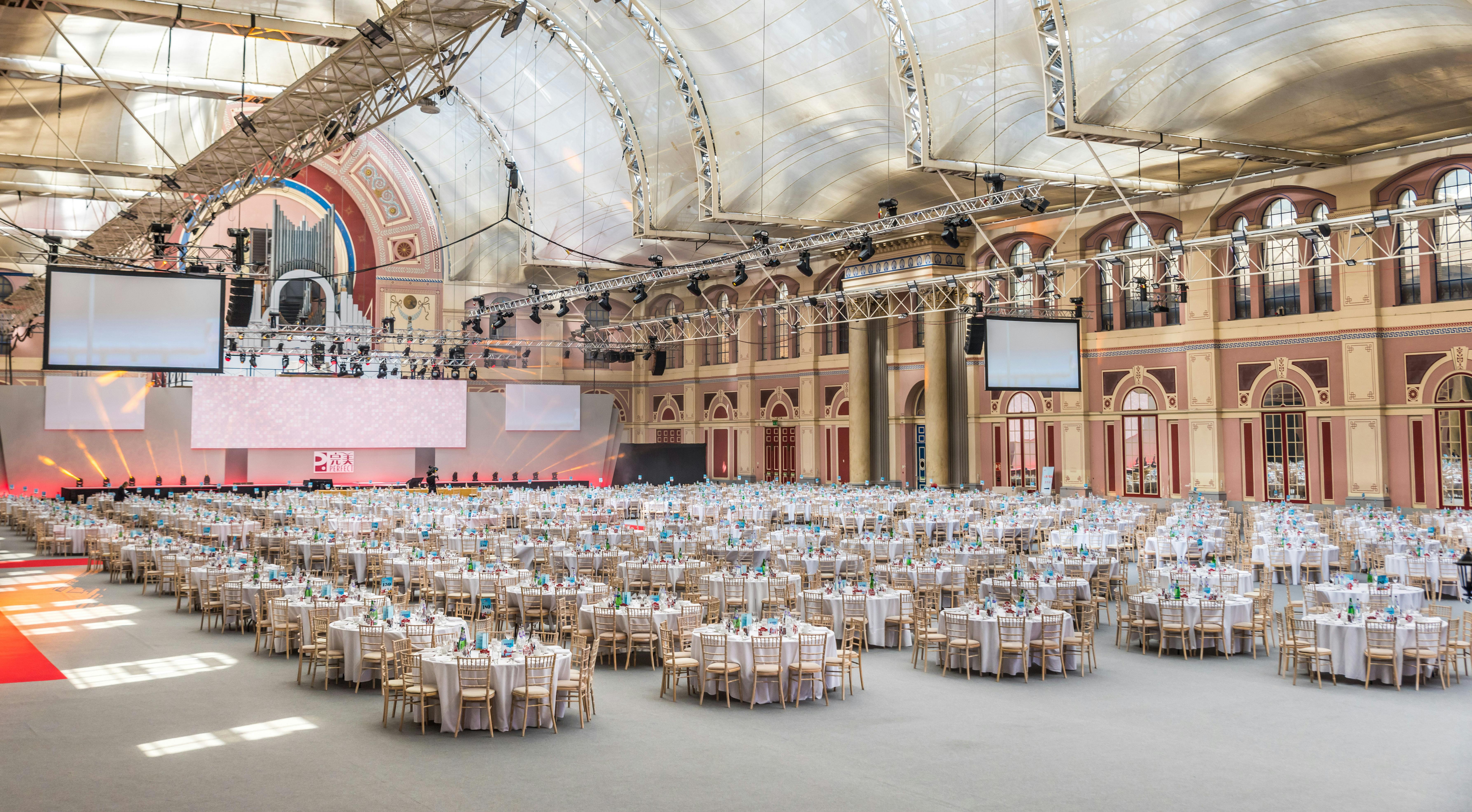 Great Hall at Alexandra Palace set for a grand banquet with elegant round tables.