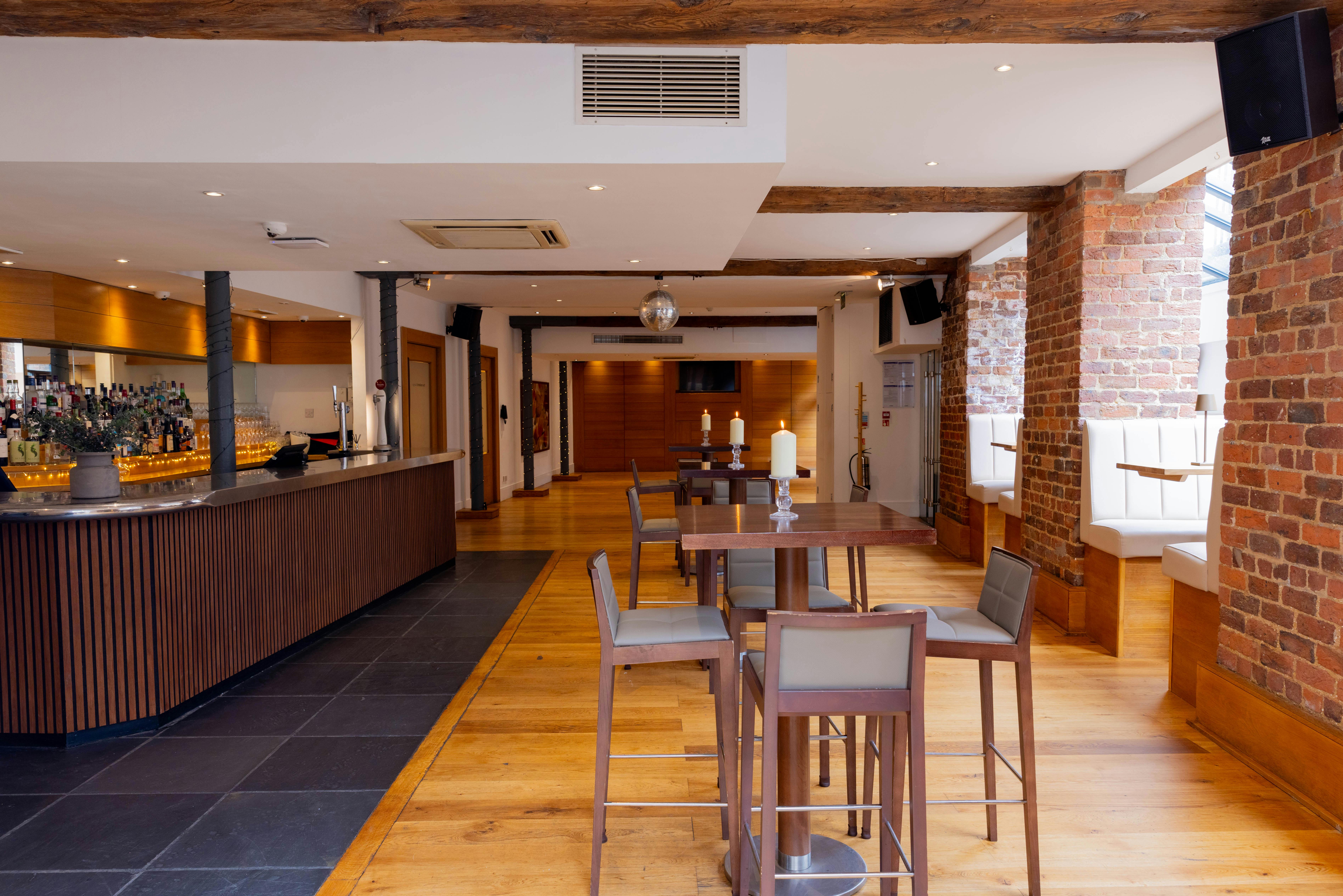 Modern event space with bar, warm wood floors, ideal for gatherings and meetings.