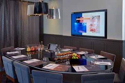 Modern meeting room in Malmaison London with oval table for corporate events.